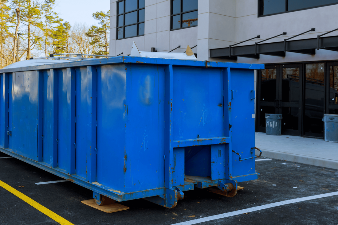 blue dumpster outside office building for rental