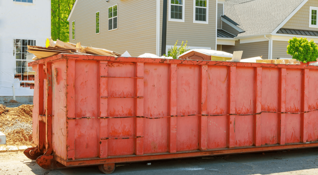 red dumpster rental at house for junk removal